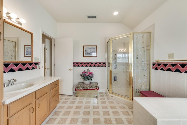 full bath featuring tile walls, a wainscoted wall, a stall shower, and visible vents