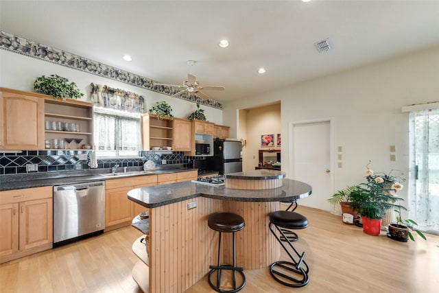 kitchen featuring decorative backsplash, light brown cabinetry, a center island, open shelves, and stainless steel appliances