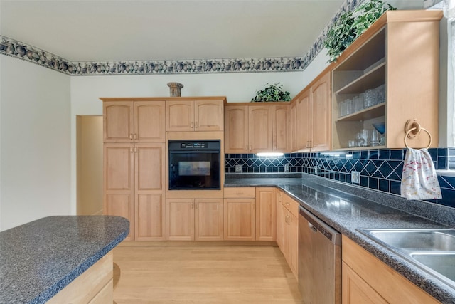 kitchen with light brown cabinetry, dark countertops, light wood finished floors, black oven, and stainless steel dishwasher