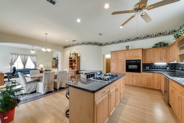 kitchen with backsplash, appliances with stainless steel finishes, light wood-style flooring, and ceiling fan with notable chandelier