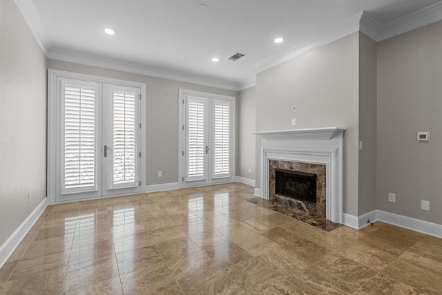 unfurnished living room featuring baseboards, ornamental molding, a fireplace, and visible vents