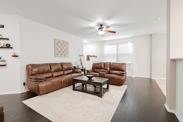 living room featuring baseboards, ceiling fan, and dark wood-type flooring