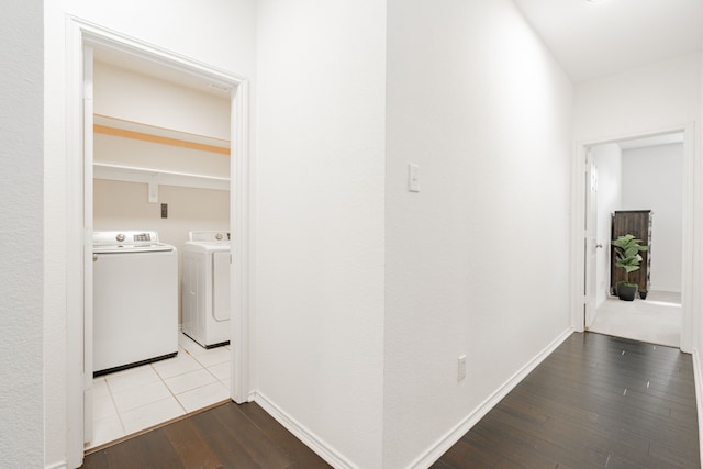 hall with separate washer and dryer, baseboards, and wood finished floors
