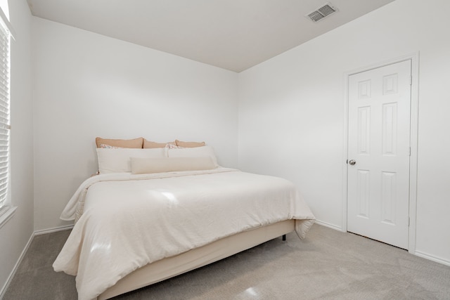 carpeted bedroom with visible vents and baseboards