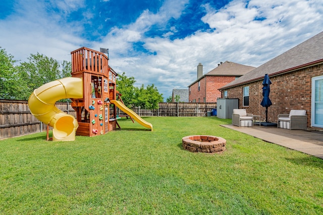 view of playground featuring a lawn, a fenced backyard, a fire pit, and a patio