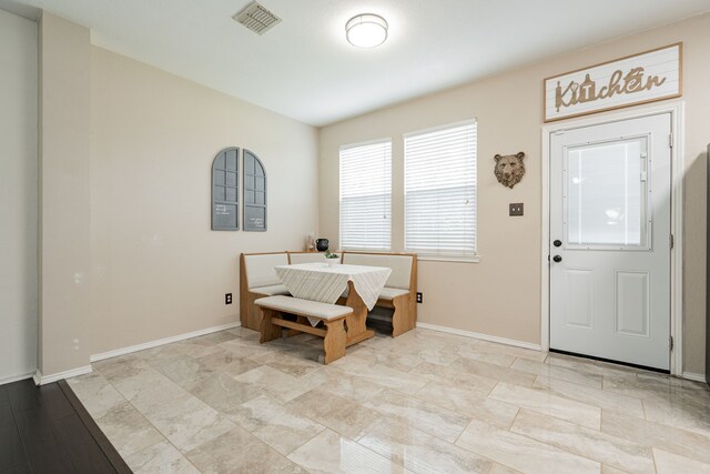 foyer featuring baseboards and visible vents
