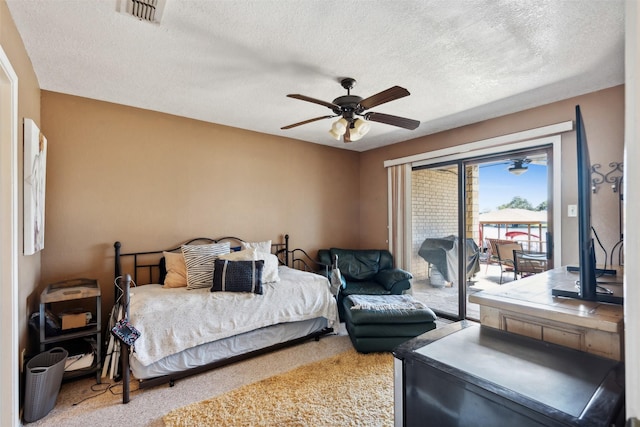 carpeted bedroom featuring visible vents, a ceiling fan, a textured ceiling, and access to outside