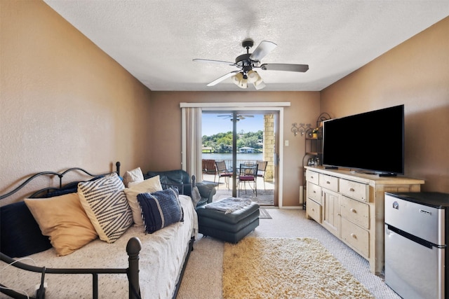 living area with a textured ceiling, ceiling fan, and light carpet