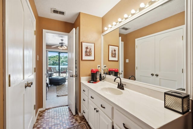 bathroom featuring vanity, ceiling fan, baseboards, and visible vents