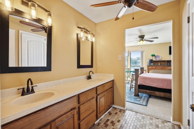 full bathroom with double vanity, a sink, ceiling fan, and ensuite bath