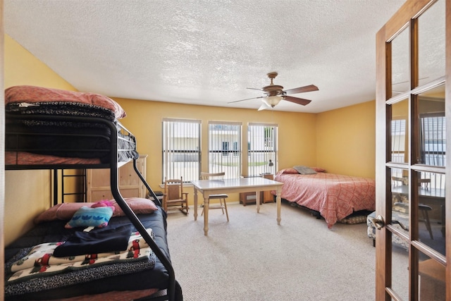 carpeted bedroom featuring a textured ceiling and ceiling fan