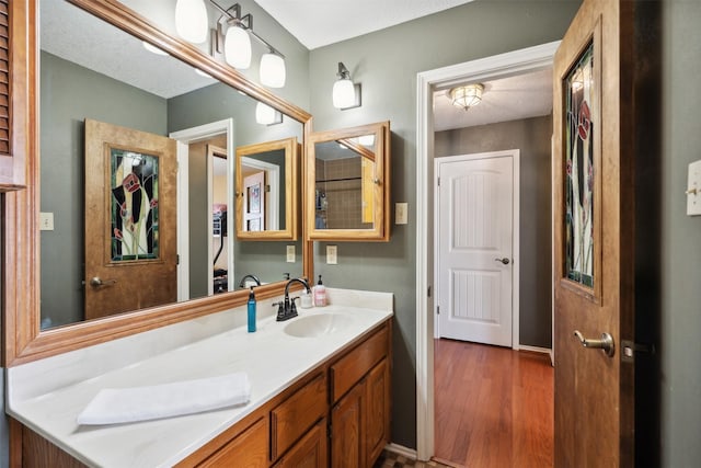 bathroom with vanity, baseboards, and wood finished floors