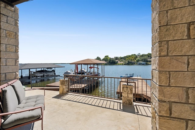 view of patio with a boat dock, boat lift, and a water view