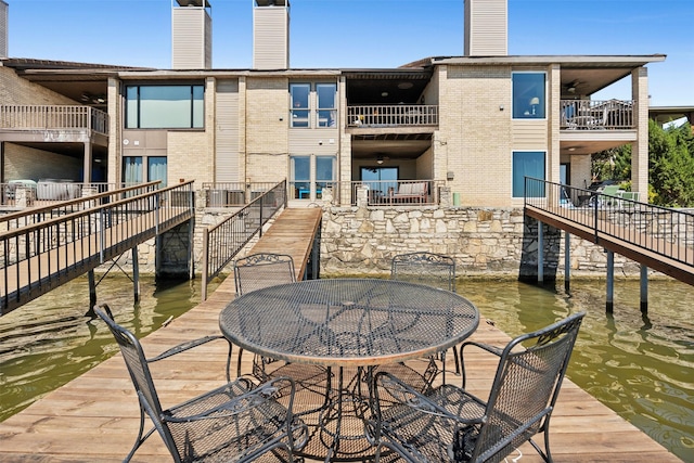 view of patio / terrace featuring stairway, a water view, and a balcony