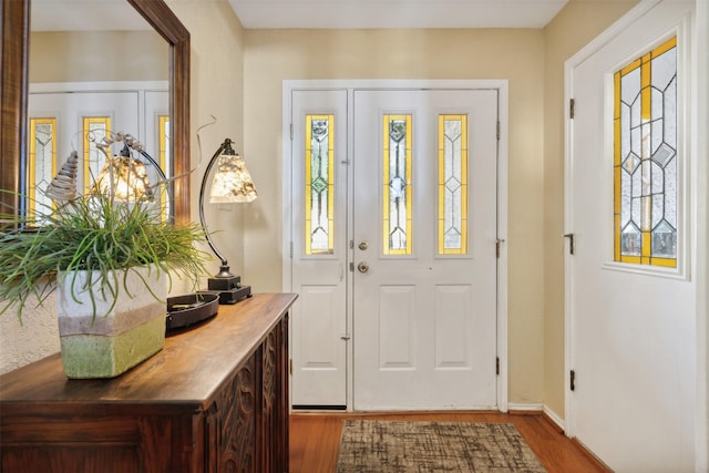 entryway featuring baseboards and wood finished floors