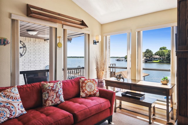interior space with a water view, vaulted ceiling, and a fireplace