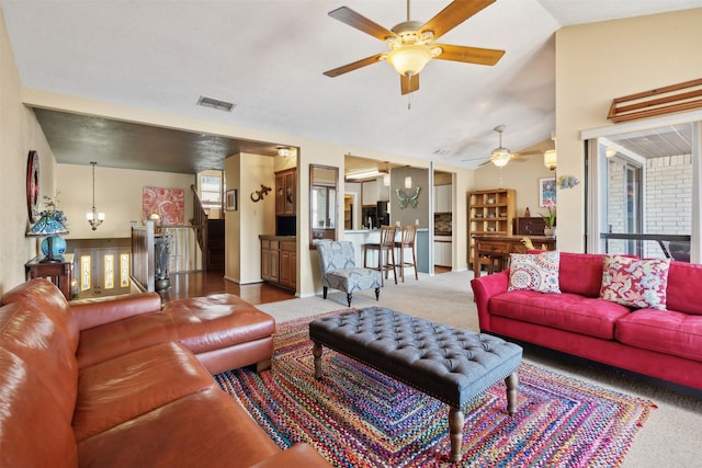 carpeted living area with ceiling fan, vaulted ceiling, and visible vents