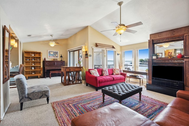 living area with ceiling fan, a fireplace, carpet flooring, and lofted ceiling