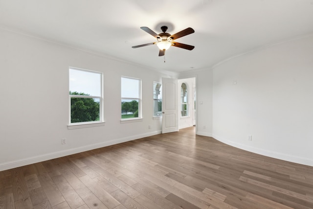 unfurnished room featuring crown molding, baseboards, ceiling fan, and wood finished floors