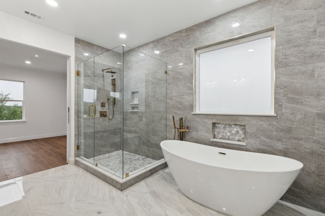 5309 Settlement Way, Mckinney, TX 75070 - bathroom featuring a freestanding bath, tile walls, a shower stall, recessed lighting, and marble finish floors
