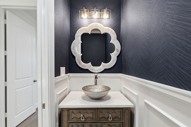 5309 Settlement Way, Mckinney, TX 75070 - bathroom featuring wallpapered walls, vanity, a wainscoted wall, and a decorative wall