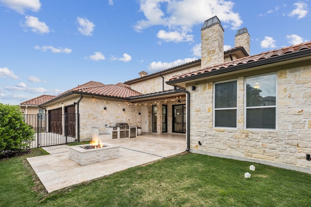 5309 Settlement Way, Mckinney, TX 75070 - back of house with stone siding, a patio area, an outdoor fire pit, a tile roof, and a chimney