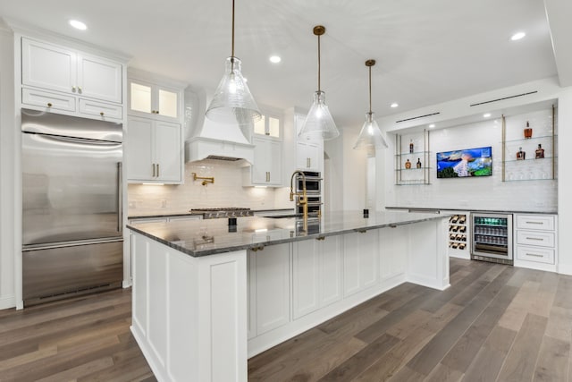 kitchen with white cabinets, beverage cooler, appliances with stainless steel finishes, and decorative backsplash
