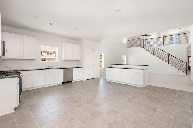 kitchen with dark countertops, tasteful backsplash, a sink, stainless steel appliances, and light tile patterned flooring