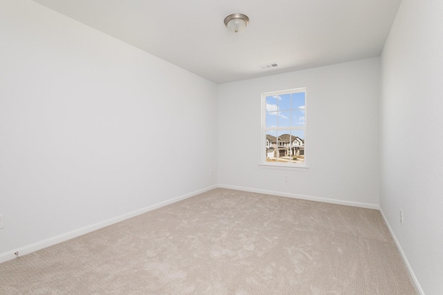 spare room with visible vents, carpet, and baseboards
