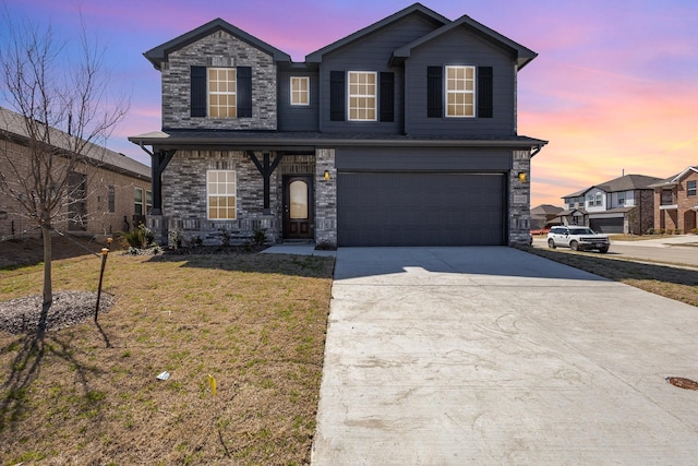 traditional home featuring a garage, a yard, and concrete driveway