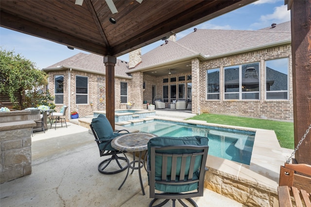 view of swimming pool with ceiling fan, a patio area, a pool with connected hot tub, and outdoor dining area