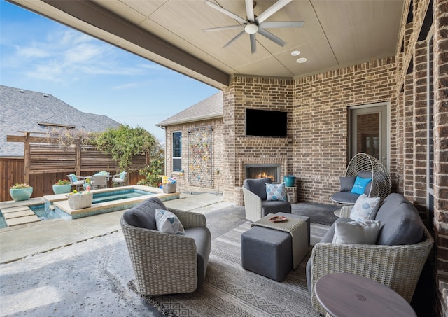 view of patio with ceiling fan, fence, and an outdoor living space with a fireplace