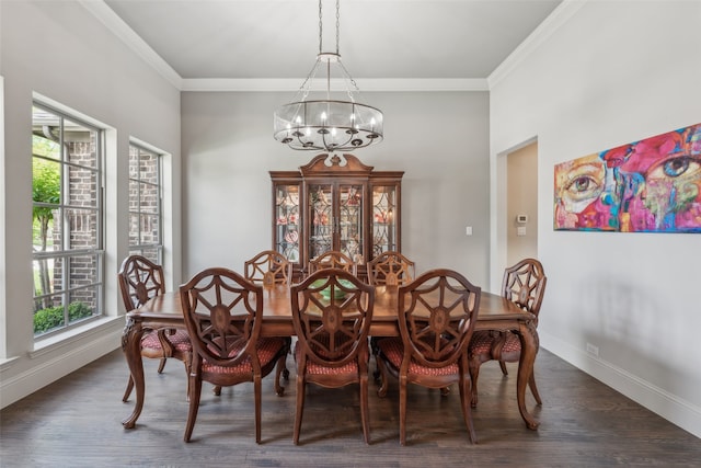 dining room featuring a chandelier, dark wood-style flooring, ornamental molding, and baseboards