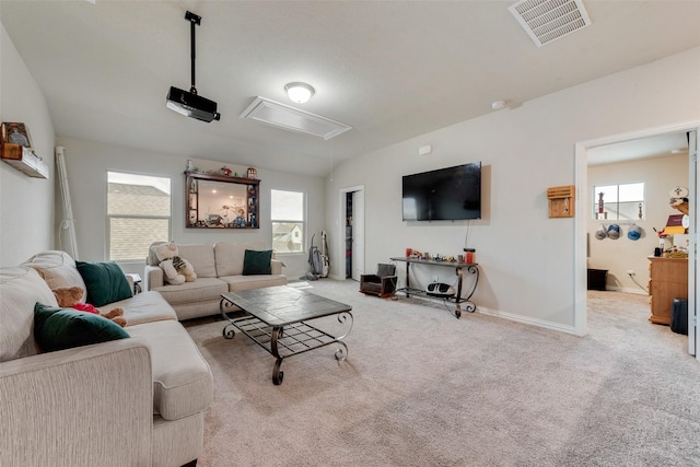 living area featuring carpet, visible vents, plenty of natural light, and attic access