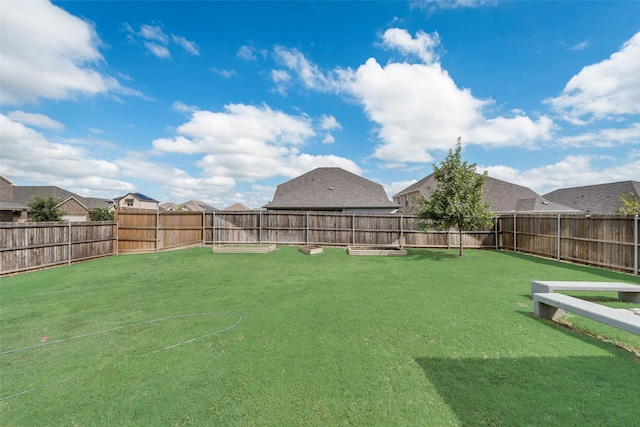 view of yard with a fenced backyard and a residential view