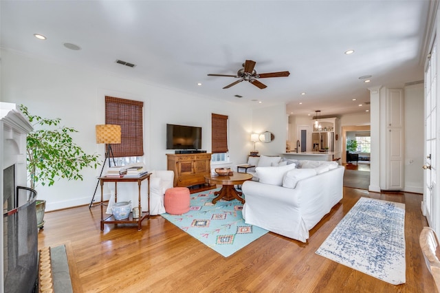 living area with visible vents, wood finished floors, baseboards, ceiling fan, and recessed lighting