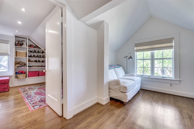 sitting room featuring vaulted ceiling, plenty of natural light, and wood finished floors