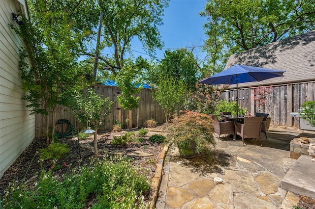 view of yard featuring a patio, outdoor dining area, and a fenced backyard