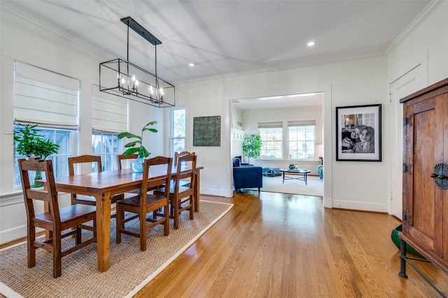 dining space featuring crown molding, baseboards, a notable chandelier, light wood-style floors, and recessed lighting