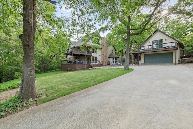view of front of home featuring a front lawn, a garage, stairway, a balcony, and driveway