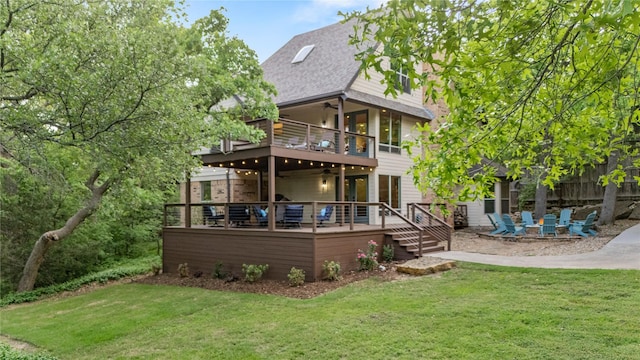 back of house with a ceiling fan, a wooden deck, a balcony, a yard, and a patio
