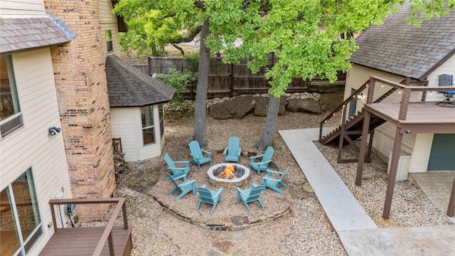 view of yard with an outdoor fire pit, fence, stairway, and a deck