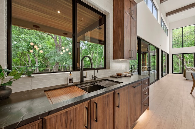 kitchen featuring a sink, dark countertops, tasteful backsplash, and brown cabinetry
