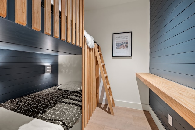 bedroom with baseboards and wood walls