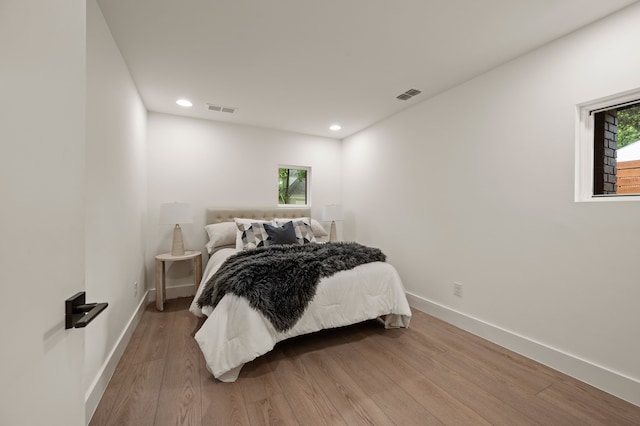 bedroom featuring baseboards, visible vents, and wood finished floors