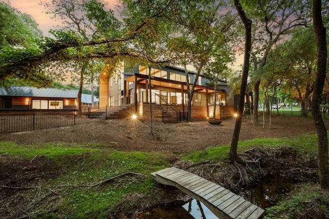 back of property at dusk featuring fence private yard