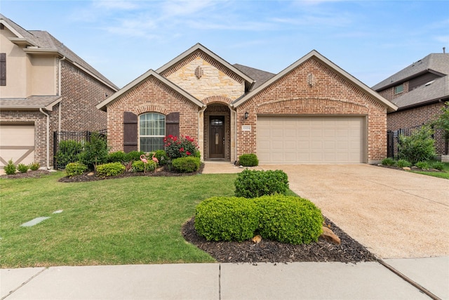 view of front of house with fence, brick siding, a garage, a front yard, and driveway