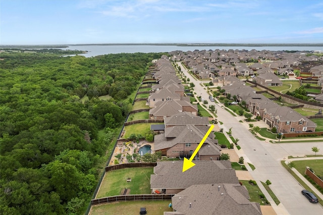 aerial view with a residential view, a view of trees, and a water view