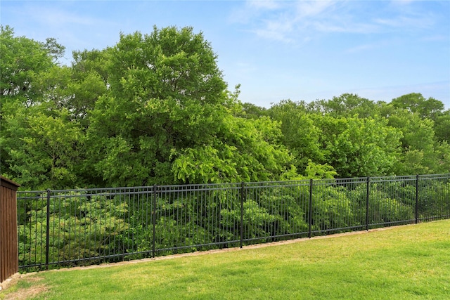 view of yard with fence and a wooded view