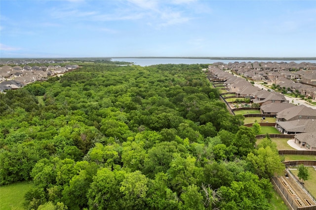 aerial view featuring a water view, a view of trees, and a residential view